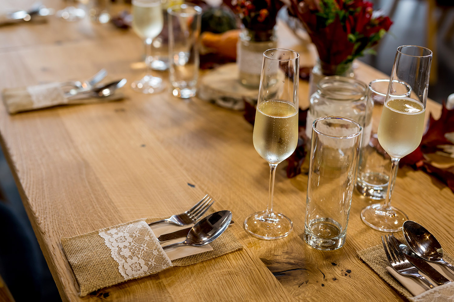 Slavnostně prostřený stůl se sklenicí šampaňského.